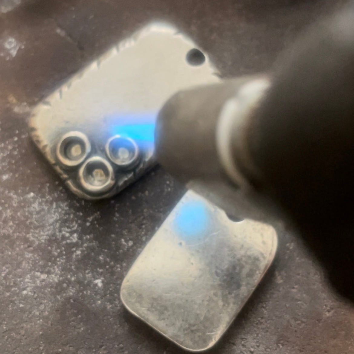 Artisan hand carving on a custom sterling silver pendant at Ella Joli