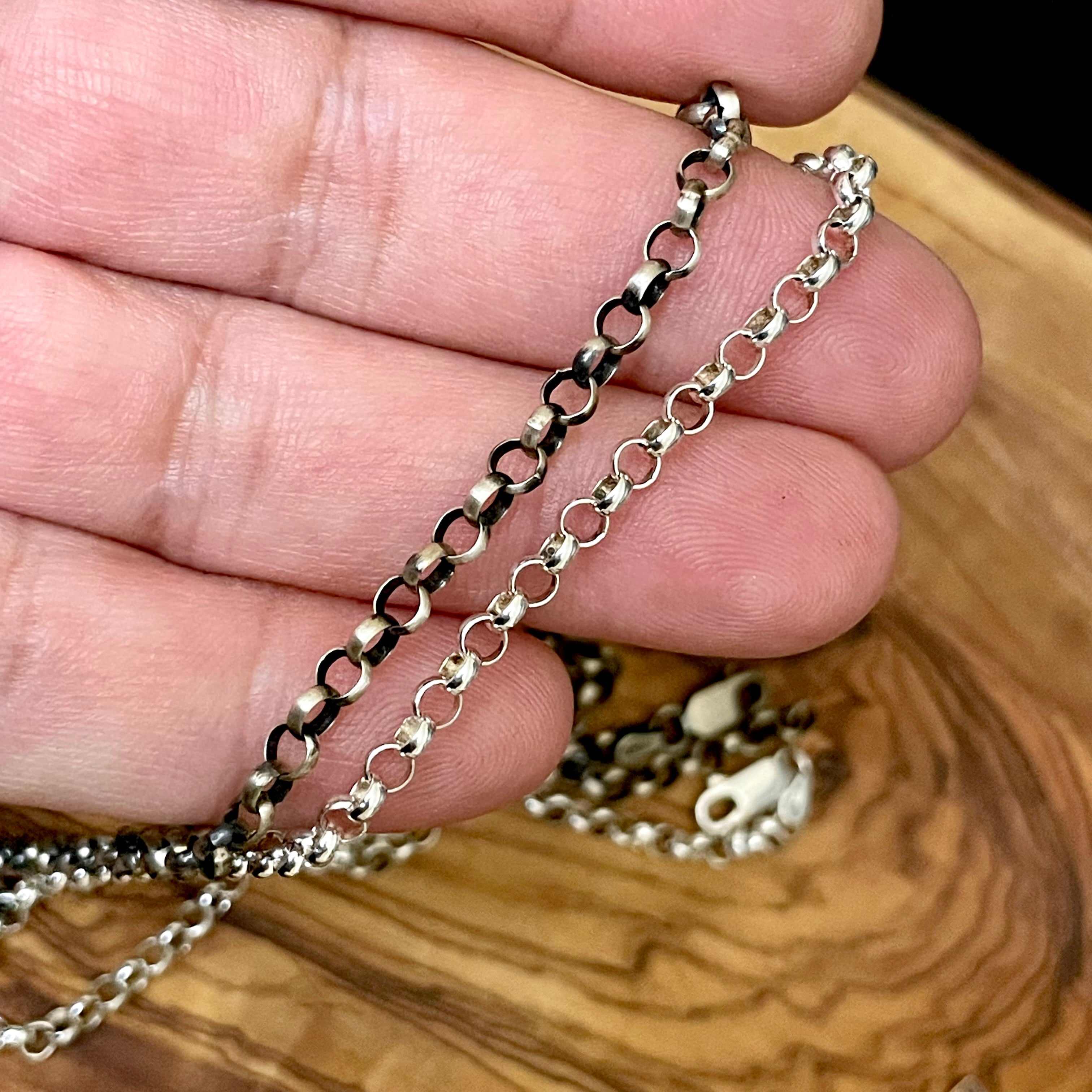 4mm rolo chain in hand. One is oxidized and one is polished sterling silver. 