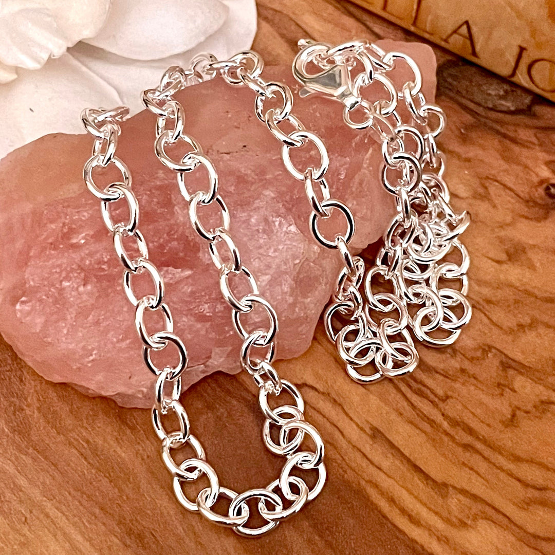 chunky sterling Silver round oval charm necklace chain or bracelet on a wooden surface with a pink stone and white flower.