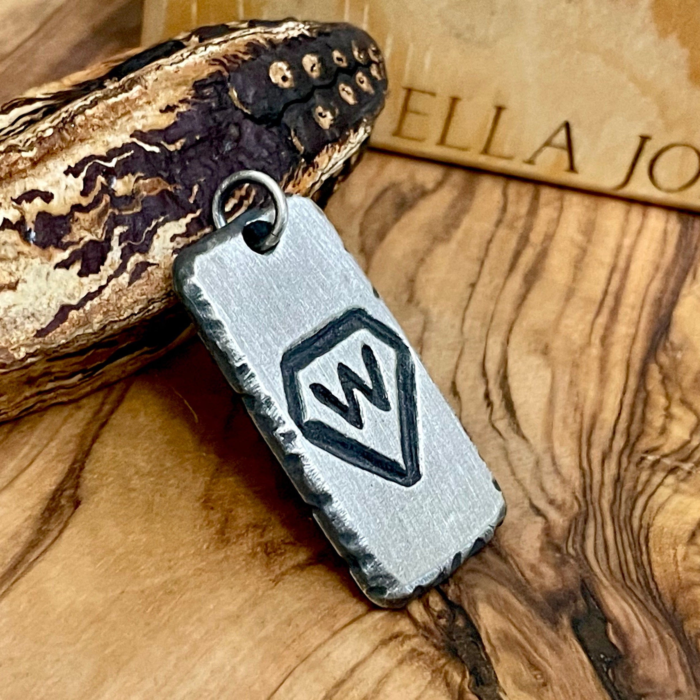 Hand carved sterling silver rectangle shaped pendant example is shown with W Diamond brand hand carved and oxidized to stand out with center placement. 