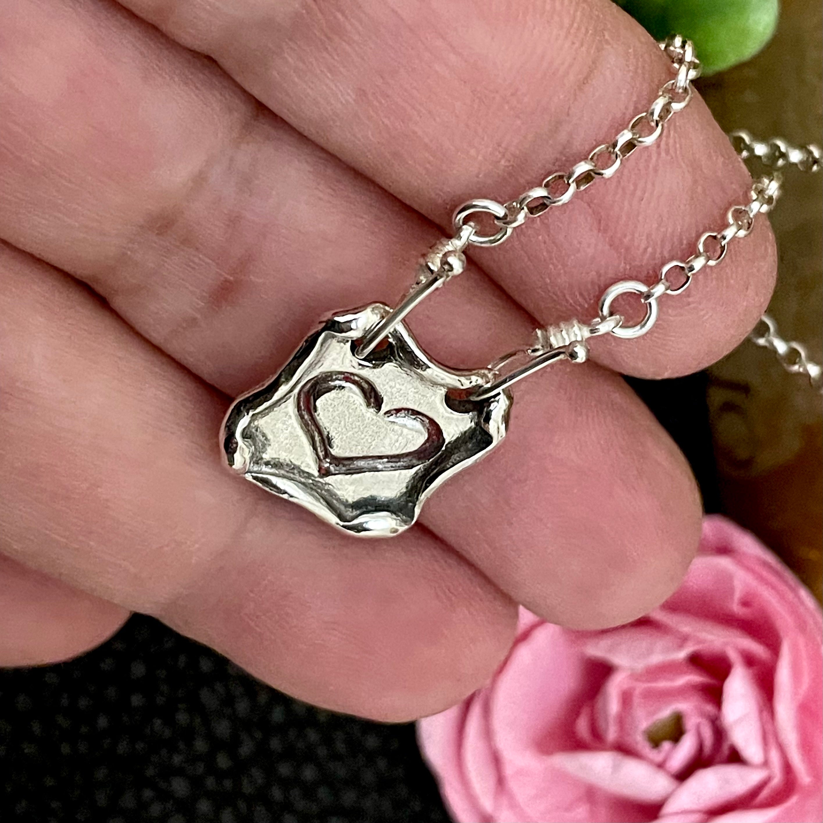 Sterling silver heart necklace in hand 