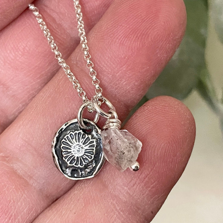 birthstone charm necklace with birth month flower charm of daisy and herkimer diamond natural crystal stone in hand