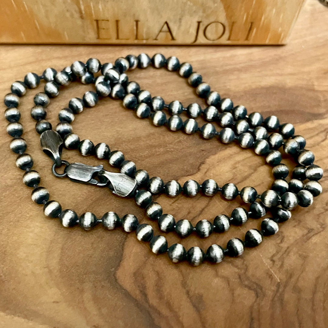 Silver beaded necklace on a wooden surface with 'ELLA JOLI' branding. Choose from 1.8mm 3mm or 4mm thicknesses. 