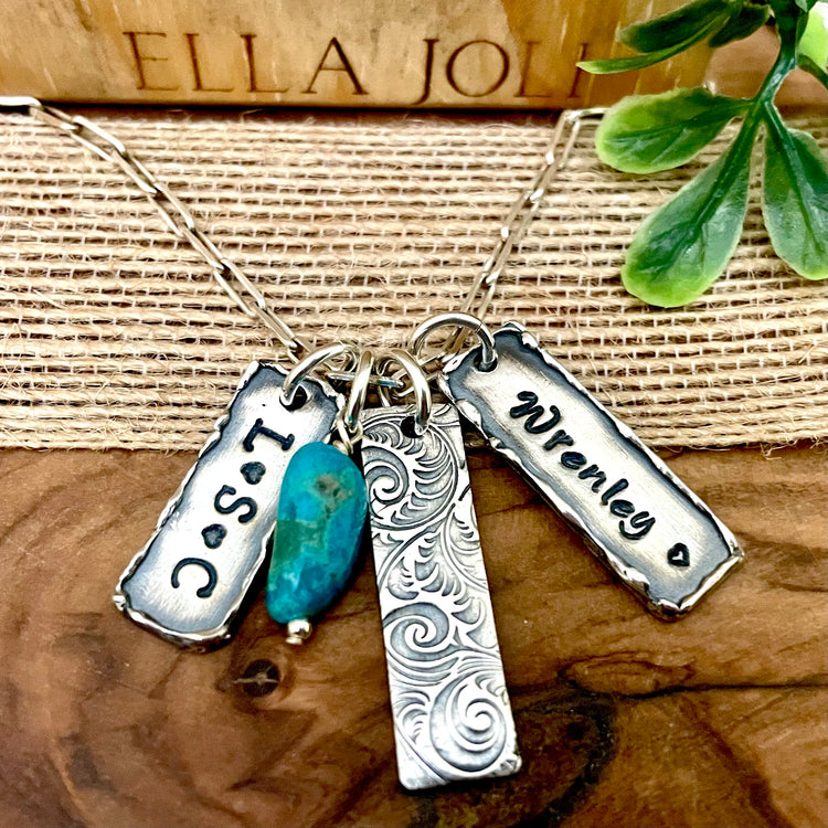 Sterling silver necklace with three engraved pendants and a turquoise drop charm on a wooden surface. Build your own custom necklace with names, initials, dates, birthstones. Rustic Minimal 