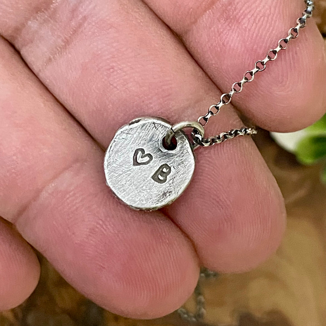 Silver necklace with a heart and &