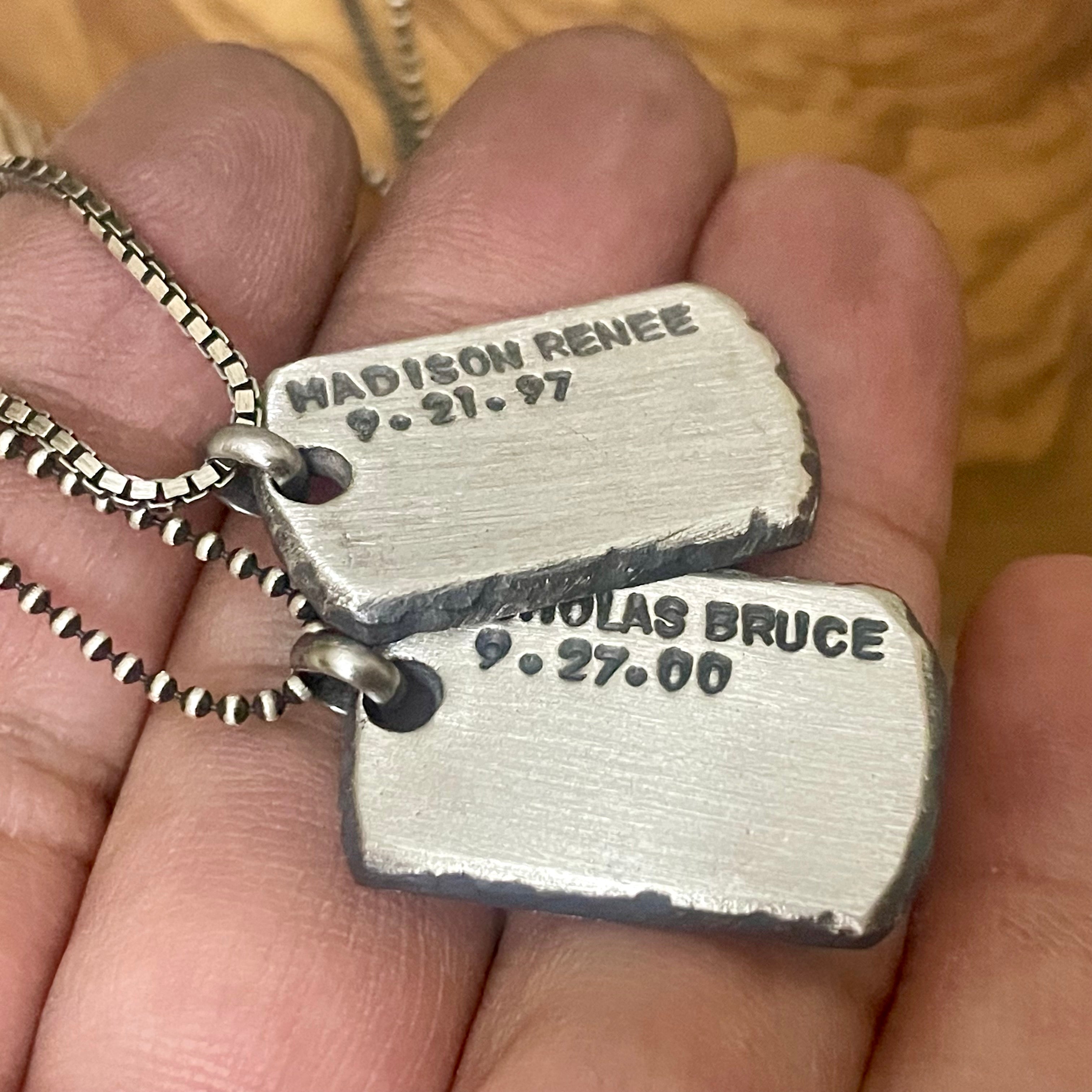 Two hand forged engraved sterling silver dog tag style pendants in hand 