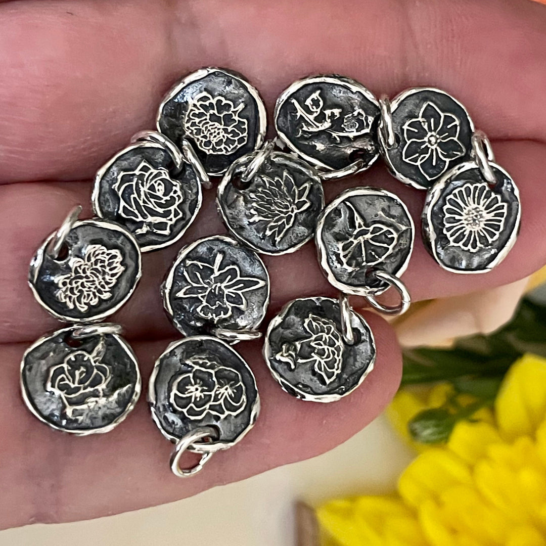 12 sterling silver flower charms in hand