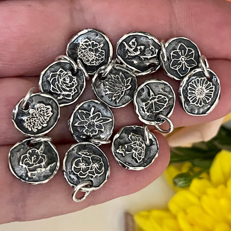 12 sterling silver flower charms in hand