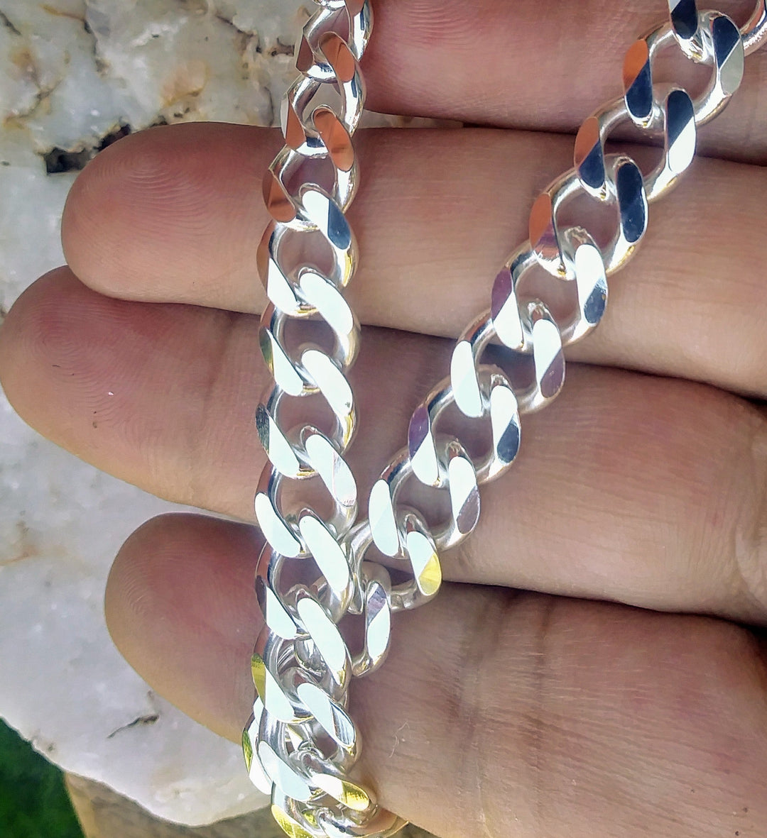 Heavy sterling silver curb chain necklace 10mm in width with lobster clasp, displayed in hand. 