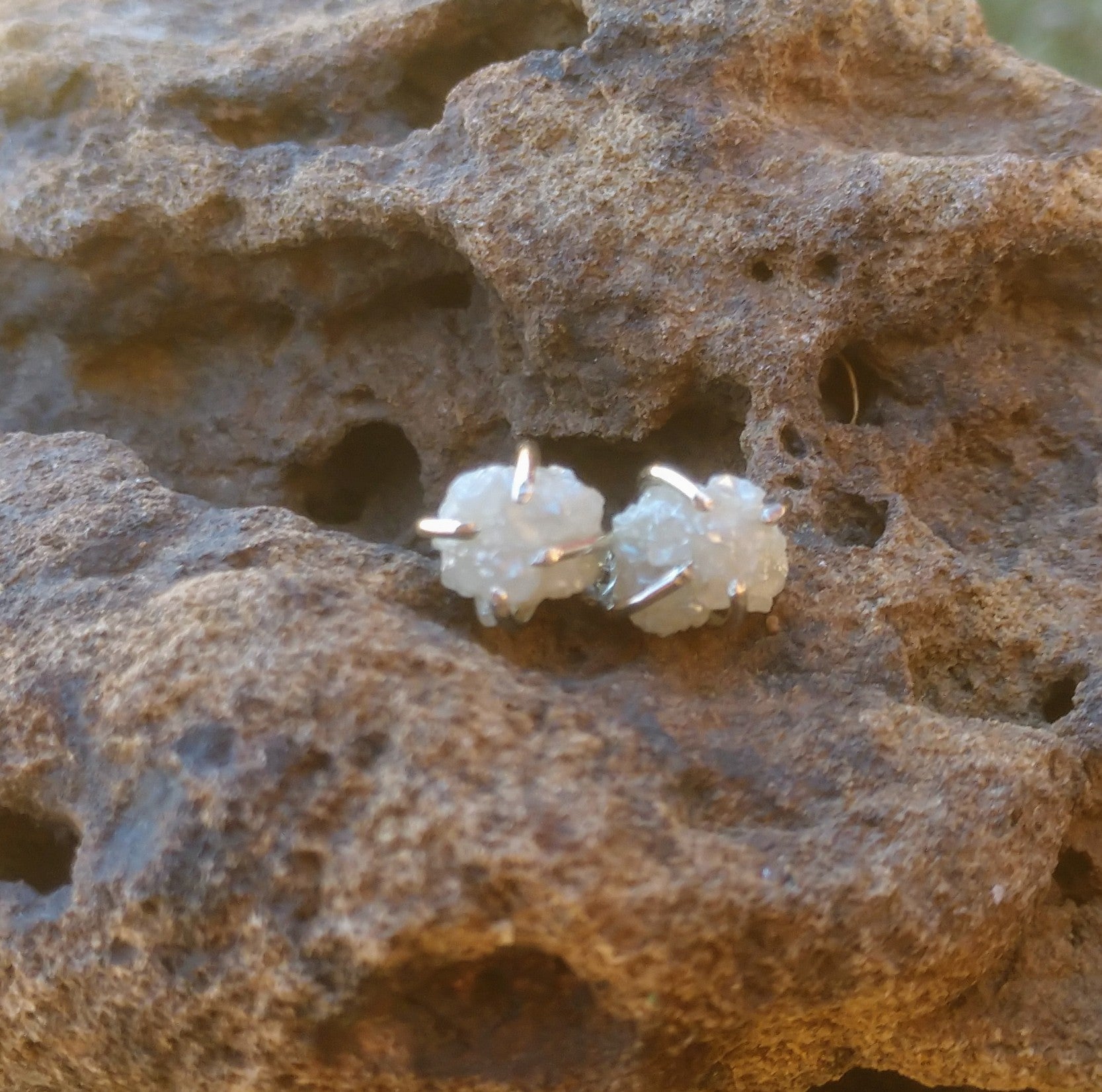 Rough diamond earrings on brown stone